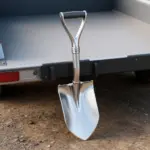 Close-up of a well-welded shovel and tool holder on a rugged trailer, showcasing shiny welds.